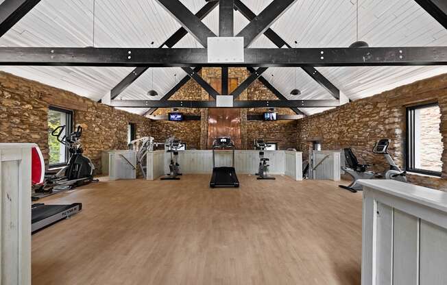 A gym with a wooden floor and a brick wall. at Mill House at East Cobb, Marietta, GA 30067