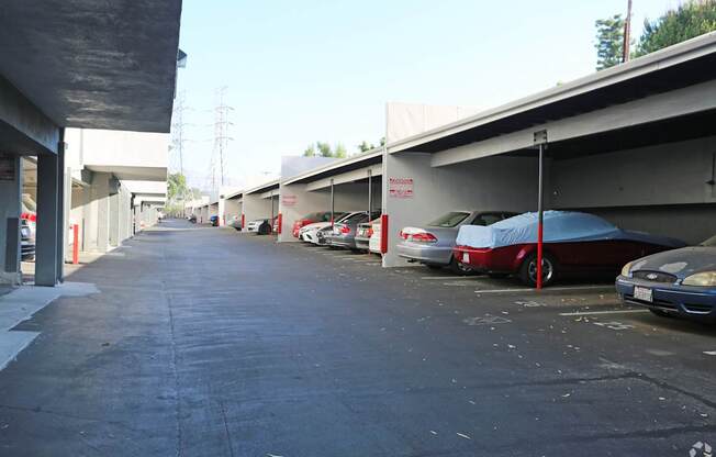 A parking lot with cars and a blue umbrella.