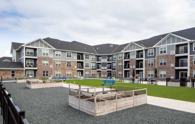 an exterior view of an apartment complex with a playground and grassy area