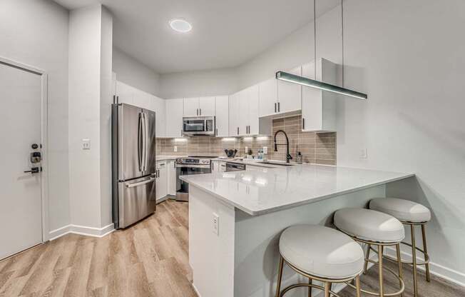 A kitchen with white cabinets and a white counter top.