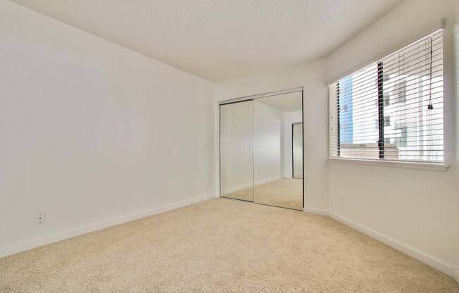 a bedroom with a mirror and a window  at Masselin Park West, Los Angeles, CA