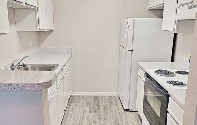 an empty kitchen with white appliances and white cabinets