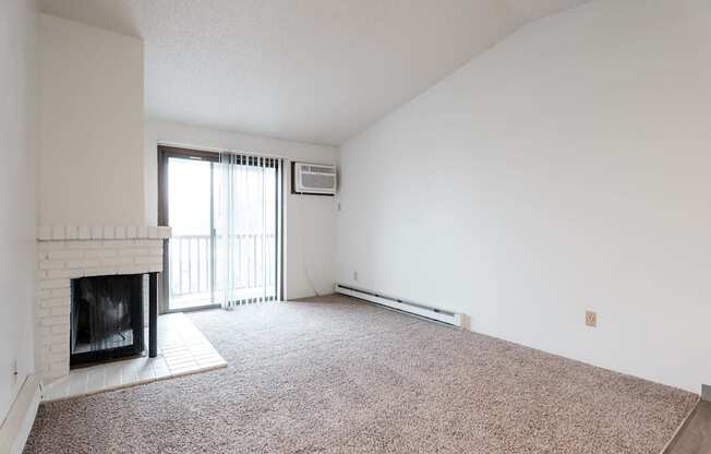 A room with a fireplace and carpeted floor. at Bristol Ridge, Urbandale, IA, 50322
