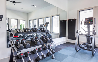 Club-quality fitness studio with free weights and elliptical. This image is a representation of the fitness studio at Amavi Brier Creek and is tentatively scheduled to open Summer 2025.