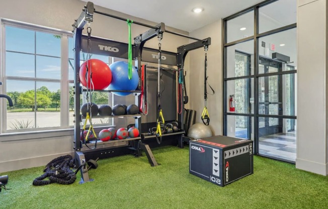 A home gym with a squat rack, a weight bench, and a bag of weights.