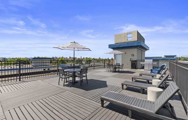 a large rooftop deck with tables and umbrellas at Guinevere Apartment Homes, Seattle