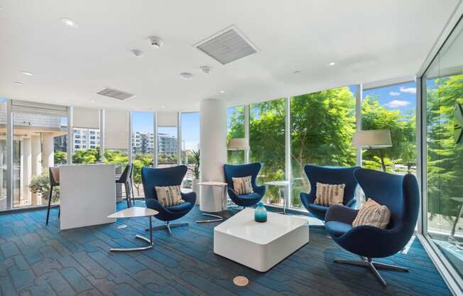 a living room filled with blue chairs and a white table