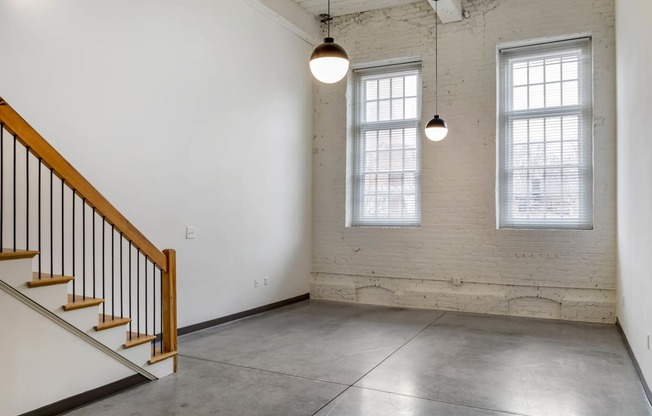 an empty room with two windows and a staircase at Highland Mill Lofts, Charlotte, North Carolina