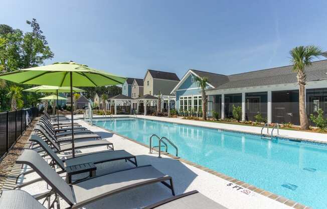 a swimming pool with lounge chairs and a building in the background