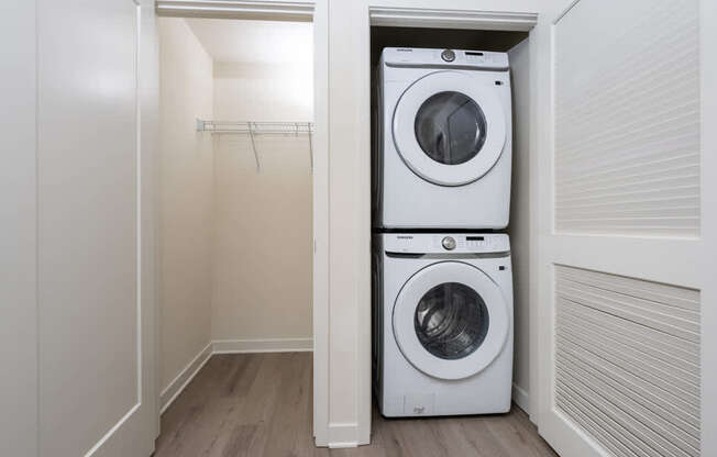 A white washing machine is in a small laundry room.