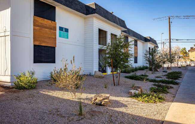 a view of the front of the building with landscaping and rocks