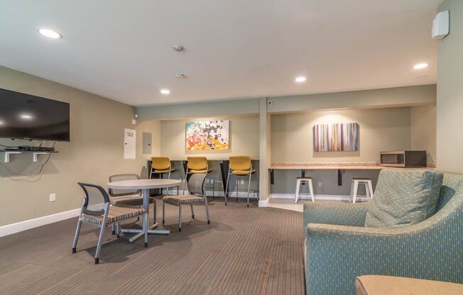 a lobby with tables and chairs and a television