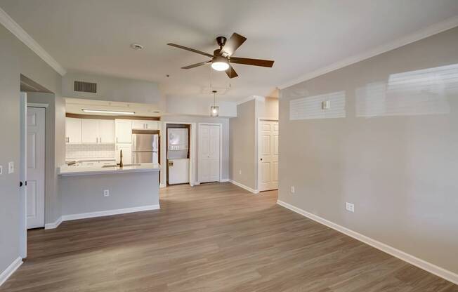 A room with a ceiling fan and wooden flooring.