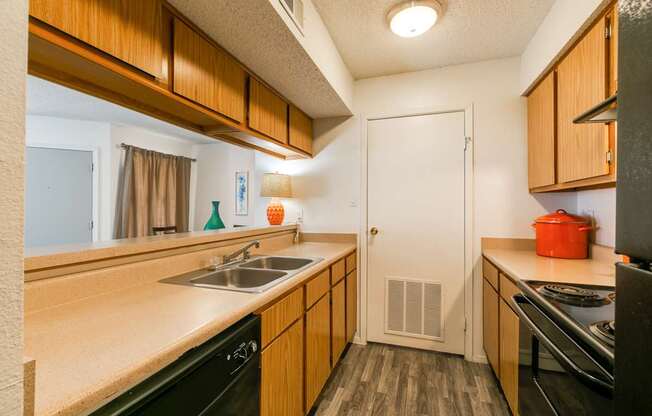 A kitchen with wooden cabinets and black appliances.