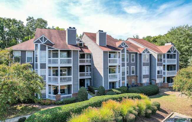 A large apartment complex with multiple balconies and a mix of brick and siding exteriors.