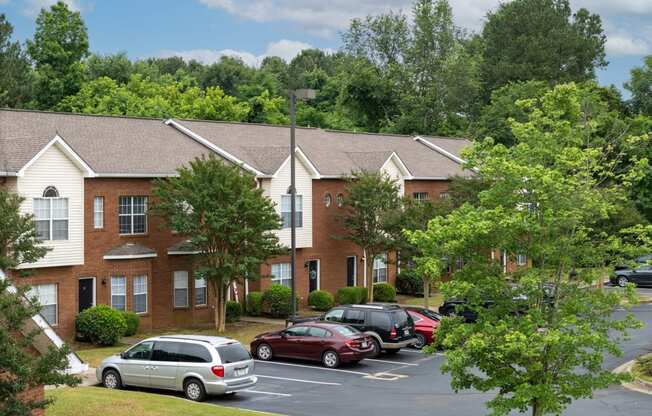 a parking lot in front of an apartment building with cars parked in the parking lot