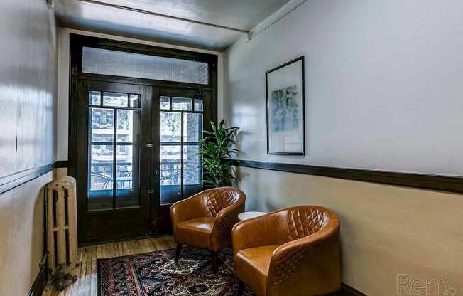 A room with a brown chair and a framed picture on the wall.