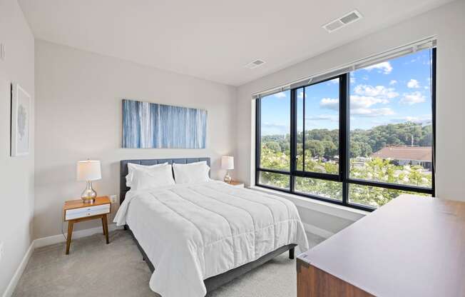 a bedroom with a bed and a large window