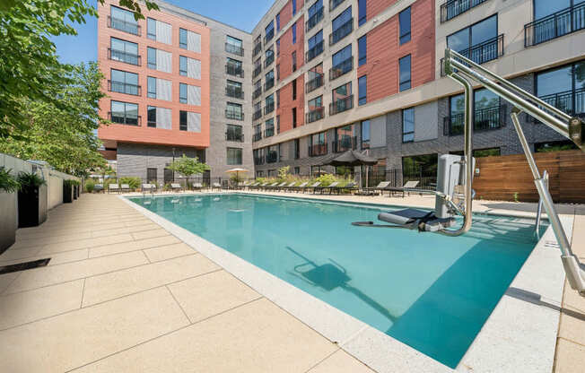 A swimming pool in a residential area with buildings in the background.