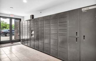 A row of stainless steel lockers are lined up in a room.
