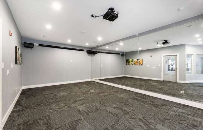 A spacious room with grey carpeting and a white ceiling.