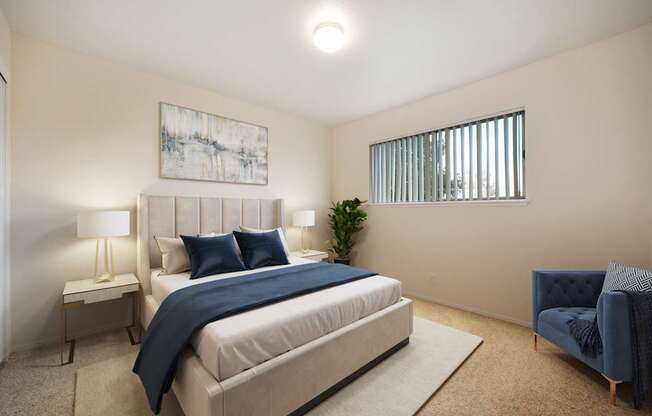 A bedroom with a large bed and a blue chair.