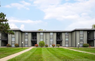 A large apartment complex with a grassy front yard.