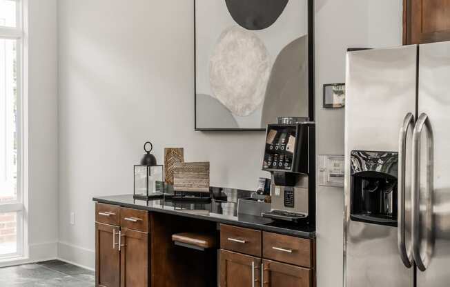 a kitchen with a stainless steel refrigerator and a counter with wooden cabinets