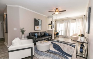 a living room with furniture and a ceiling fan