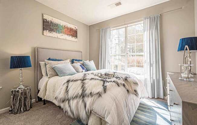 A bedroom with a large bed and a painting on the wall.