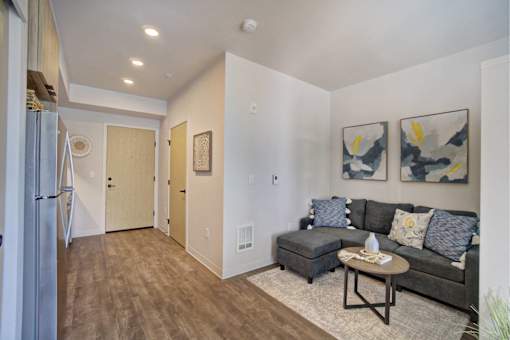 A living room with a couch, coffee table, and two paintings on the wall.