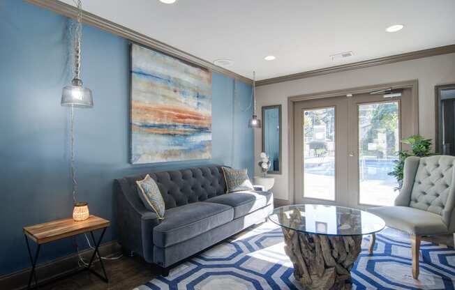a living room with blue walls and a glass coffee table
