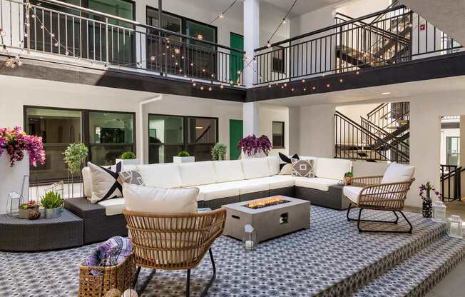 A modern living room with a white sofa and a wicker chair.