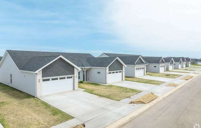 A row of houses with garages in front.