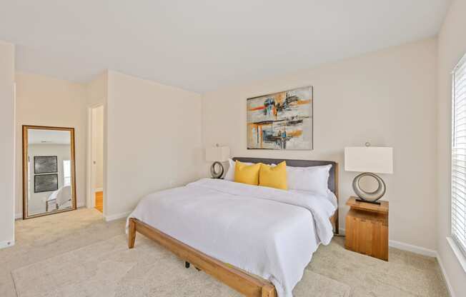 a bedroom with white bedding and yellow pillows