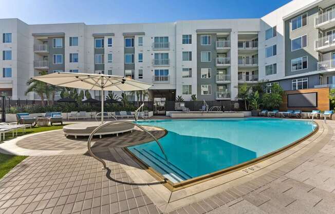 A large swimming pool in front of apartment buildings.