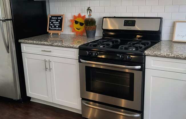 a kitchen with white cabinets and stainless steel appliances