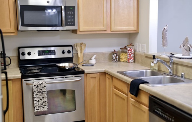 a kitchen with wooden cabinets and stainless steel appliances