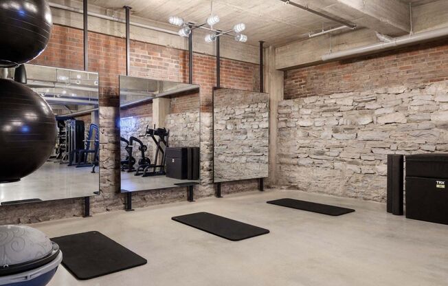 the gym has a stone wall and rugs on the floor