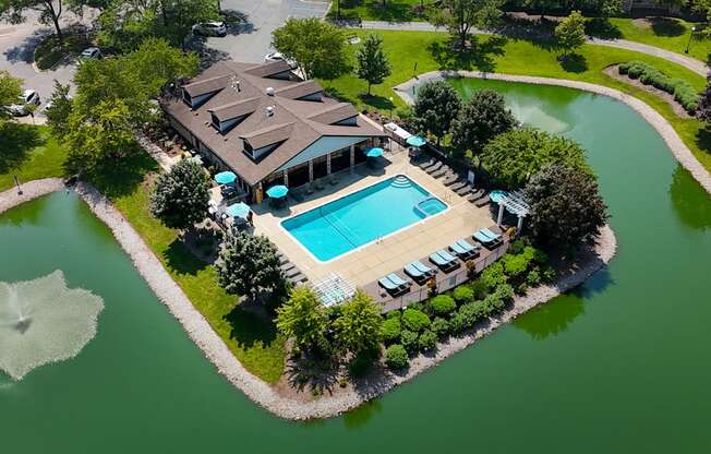 A large house with a pool sits on a small island.