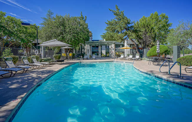 Swimming pool with resort-style furniture at Treehouse Apartments in Albuquerque, New Mexico