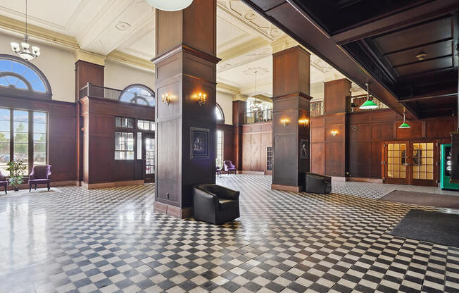 the lobby of a building with a checkered floor and columns