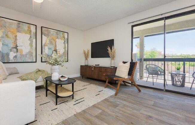 a living room with a couch and a tv and a balcony