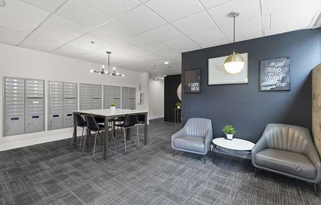 Cozy Lobby Area with a table and chairs and convenient mailboxes on the wall at Villaggio Apartment Homes, Tacoma, 98402