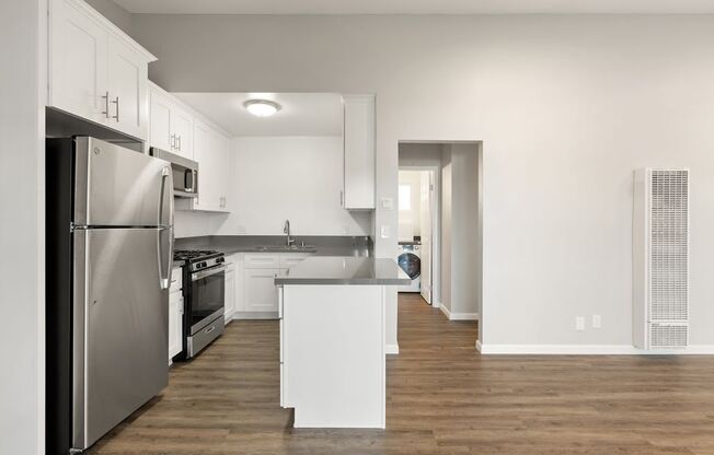 a kitchen with stainless steel appliances and white cabinets
