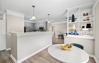 an open kitchen and dining room with a white counter top and a table