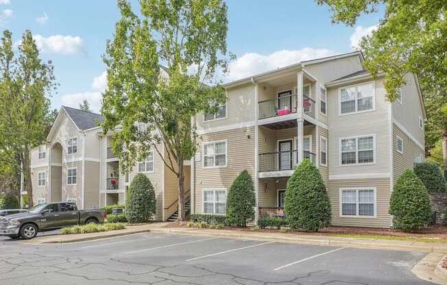 A large apartment building with a parking lot in front.