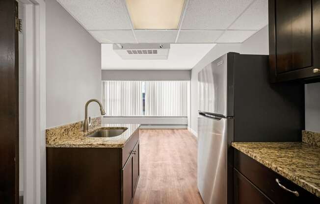 an empty kitchen with a sink and a refrigerator