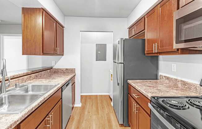 A kitchen with wooden cabinets and a black refrigerator.