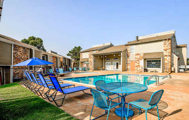 our apartments have a resort style pool with blue chairs and tables